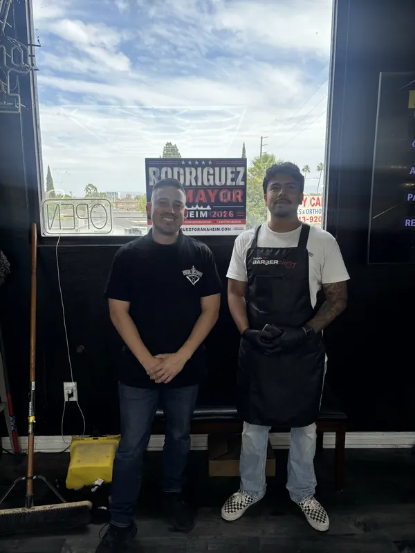 Alfredo Rodriguez with business owners and a campaign sign