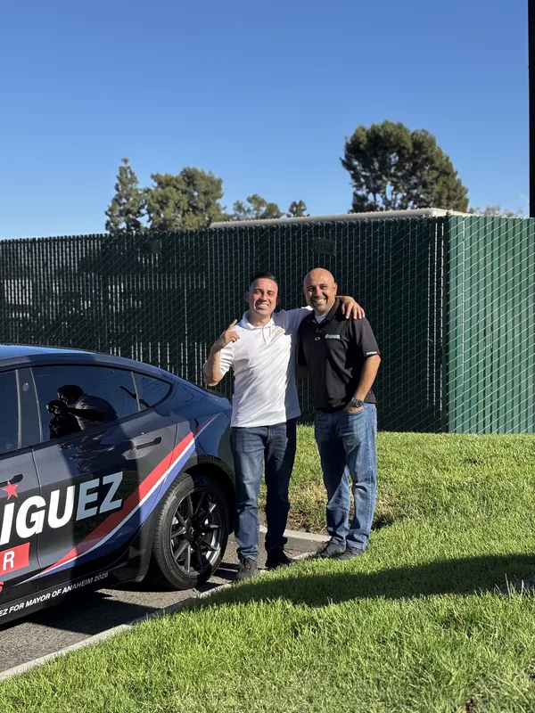 Alfredo Rodriguez with a supporter next to the campaign car